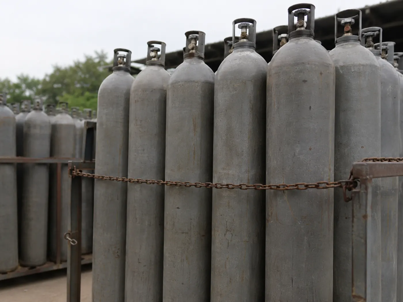 Industrial gas cylinders racked and chained, ready for delivery